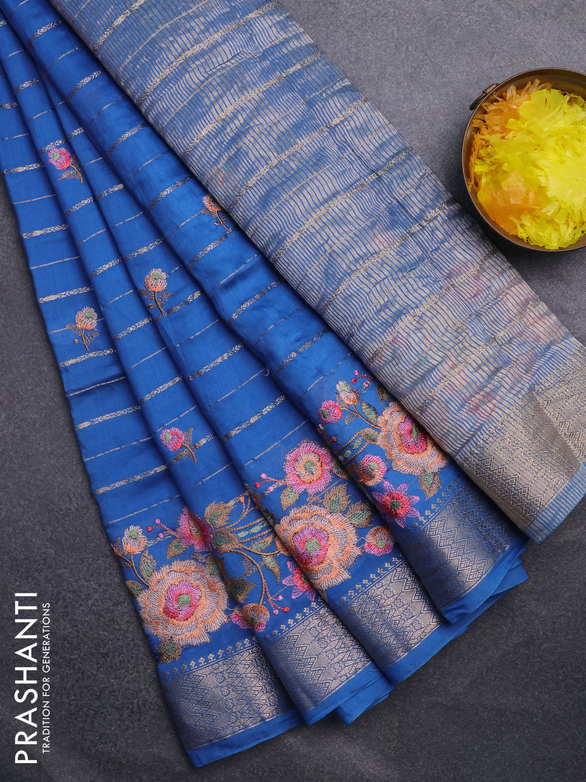 Assam silk saree cs blue with allover zari weaves & floral embroidery work buttas and zari woven border