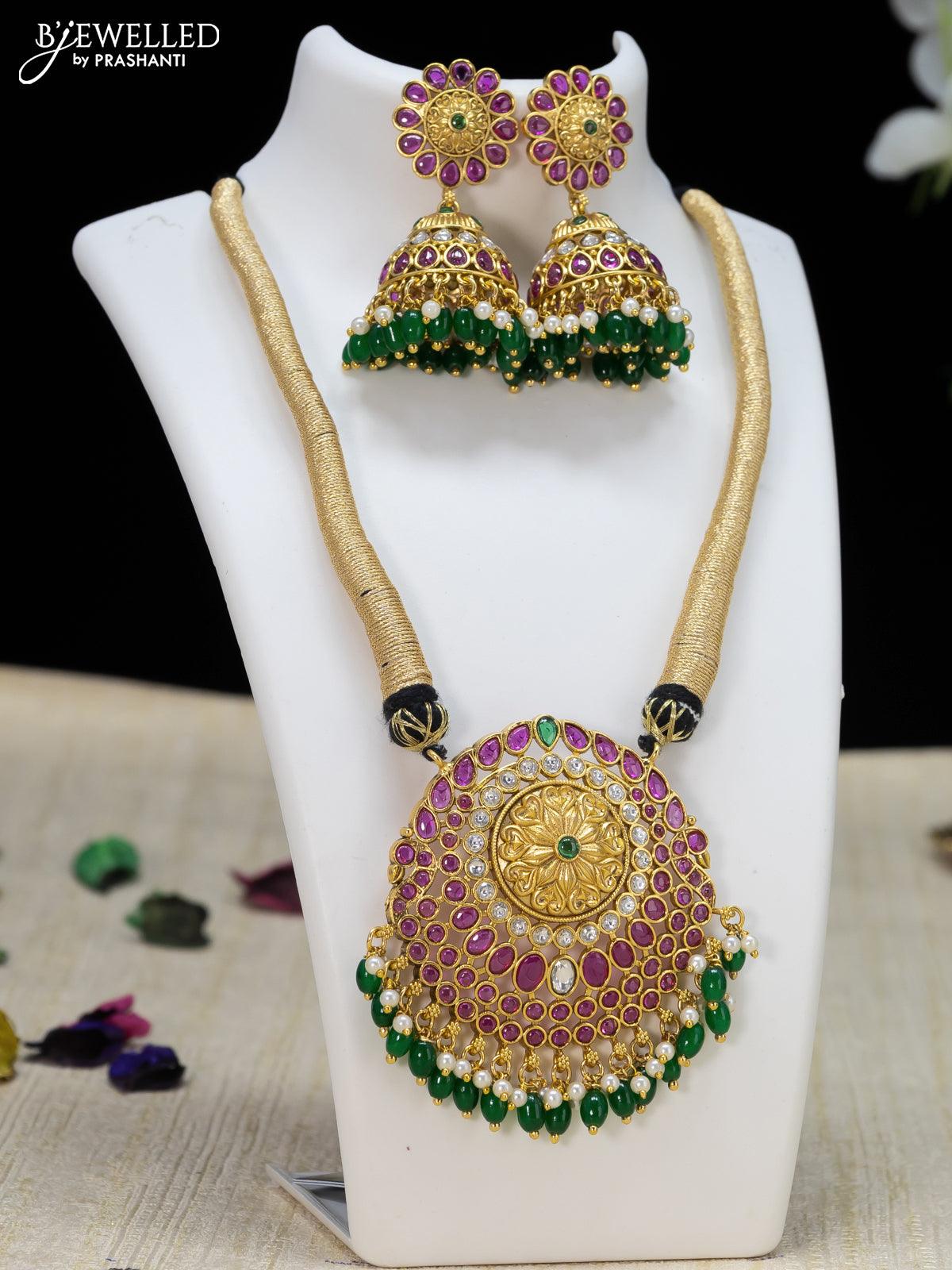 Black thread necklace with kemp stone and green beads hanging